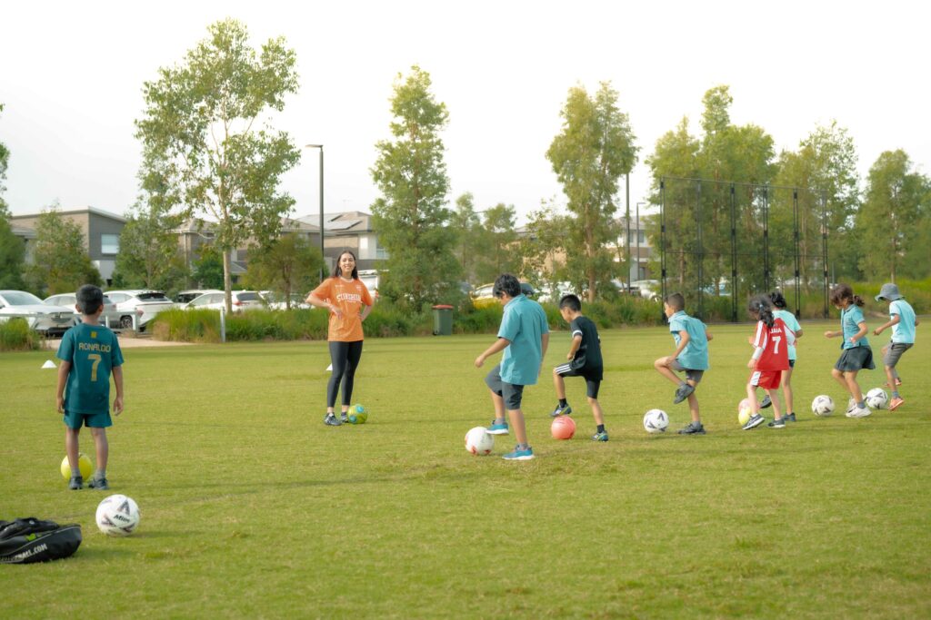 Young children learning soccer skills with a Sunshine Sports coach